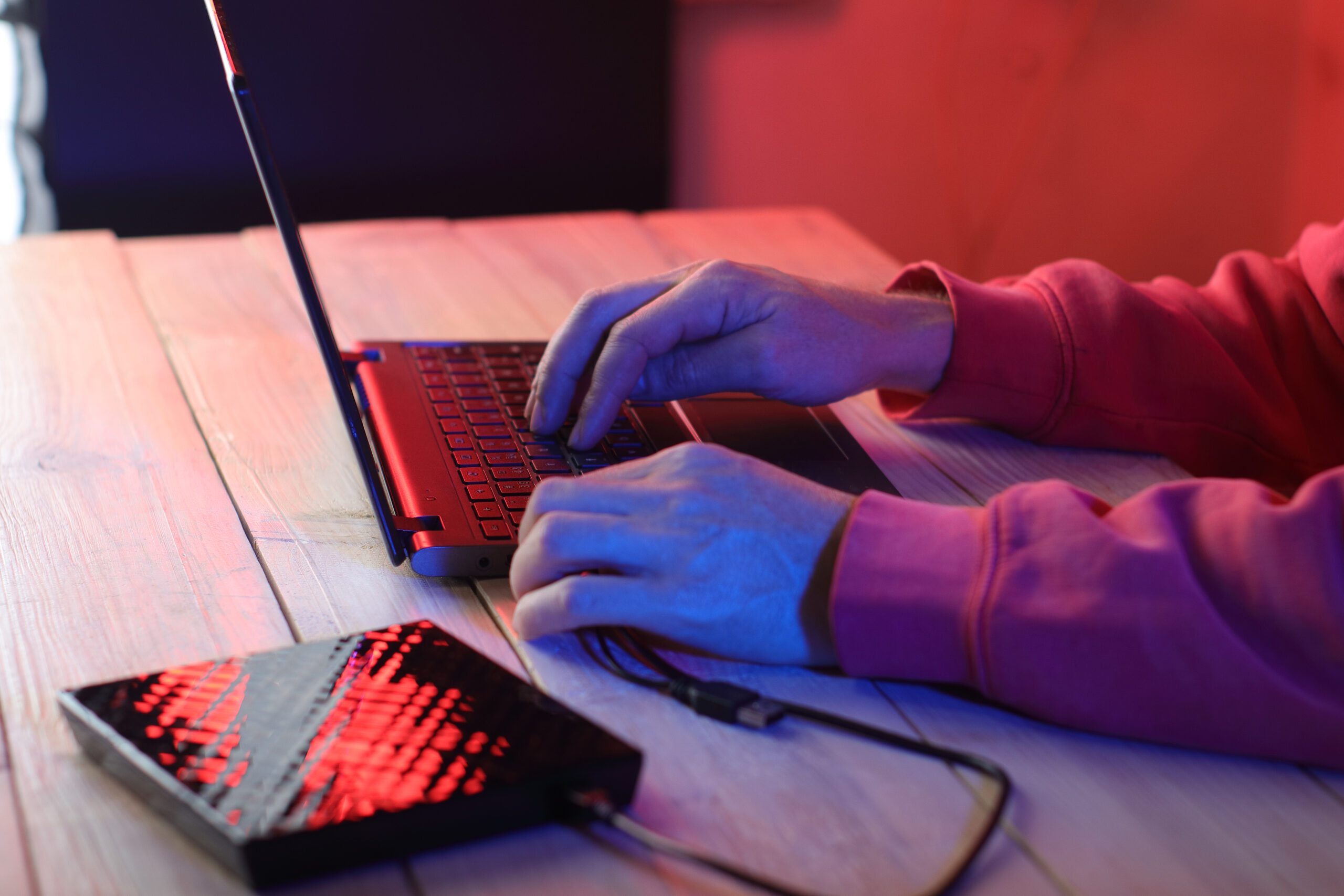 laptop with attached optical drive on the table in front of a person