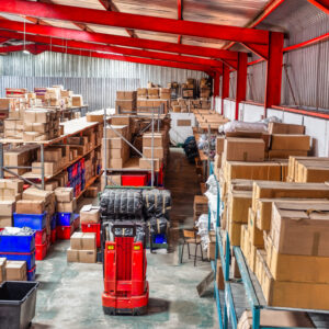 huge warehouse  with carton card and plastic crates boxes in shelfs, high point of view