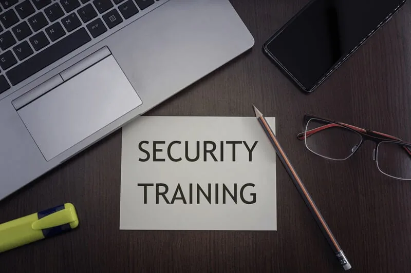 Note reading security training on a desk with a laptop, glasses and pencil