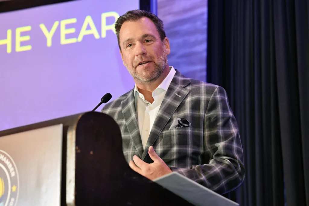 Robert Hessel speaking at a podium while accepting a Business Owner of the Year award