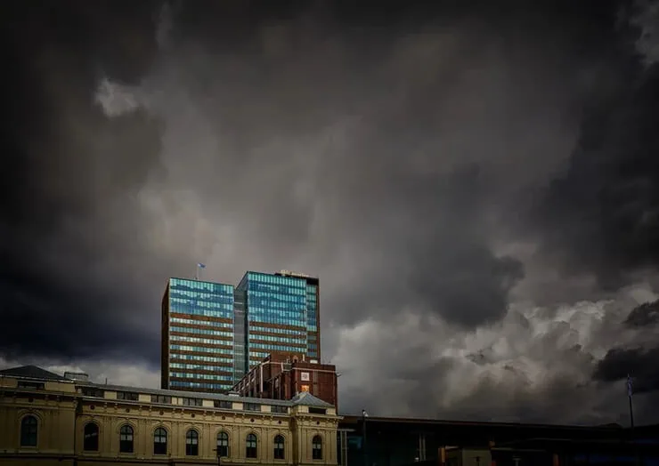 Dark storm clouds gathering over a downtown office building during hurricane season