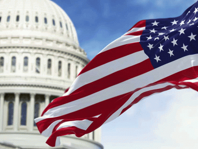 American flag waving in front of the U.S. Capitol dome