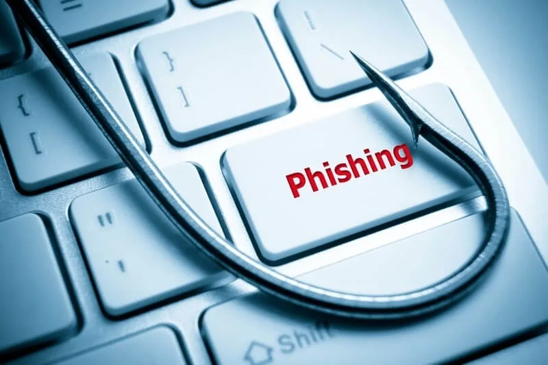 Fishing hook resting on a computer keyboard over a key labelled phishing