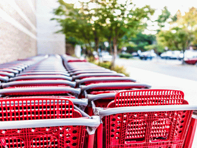 Row of red shopping carts lined up outside a retail store entrance