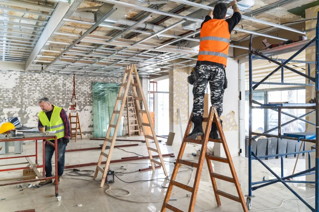 Electricians installing ceiling systems in a commercial building under construction