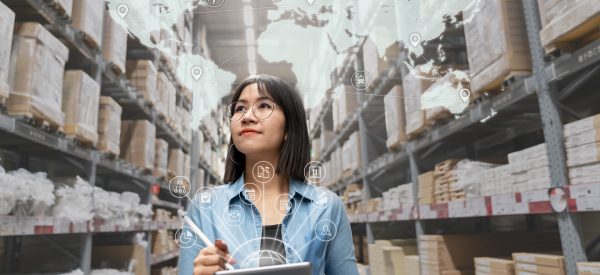 Portrait of happy young attractive asian entrepreneur woman looking at inventory in warehouse using smart tablet in management technology,  interconnected industry, asian small business sme concept.