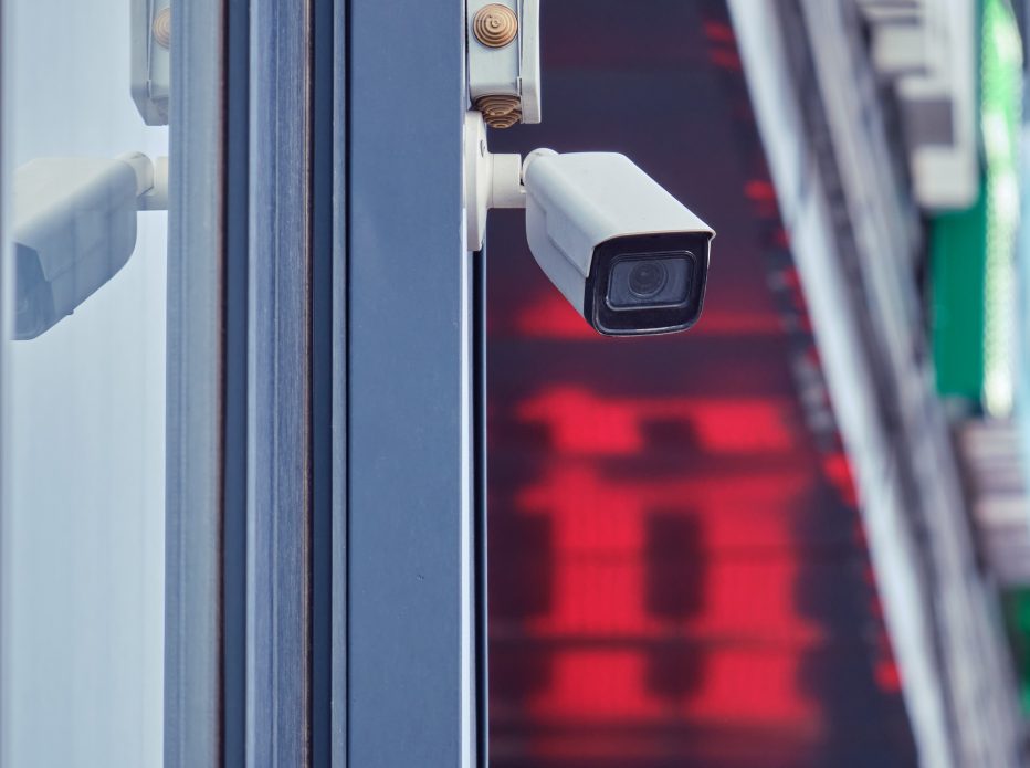 Video surveillance camera on the store building, monitoring the security of the entrance to the shopping center